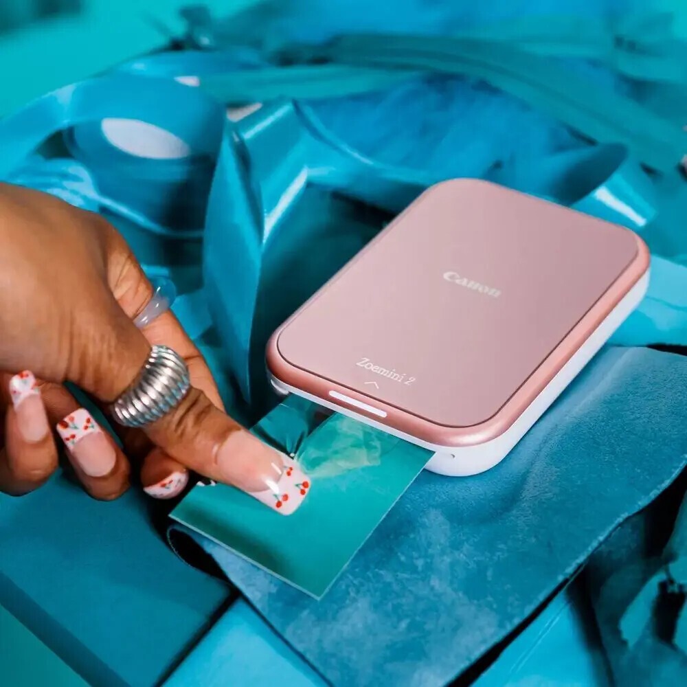 Canon Zoemini 2 5452C003 vrecková tlačiareň RGW ružová.
Vreckové rozmery, bez atramentu a pripravené na tlač fotografií kedykoľvek a kdekoľvek – je to dokonalý partner pre váš smartphone.Veľké nápady s malou tlačiarňou
Model Canon Zoemini 2 je nabíjateľná fototlačiareň, ktorá je vždy s vami, keď ju potrebujete.
Táto vrecková tlačiareň premení vaše snímky zo smartfónu na nádherné fotografie, či ste doma, vonku, alebo kdekoľvek inde.Dokonalé výtlačky pripravené na okamžité zdieľanie
Užite si a zdieľajte svoje obľúbené fotografie, nech ste kdekoľvek, s výtlačkami z modelu Zoemini 2, odolnými voči vode a roztrhnutiu.
Vďaka dokonalej vreckovej veľkosti a ľahkej konštrukcii vrátane vstavaného akumulátora s rýchlym nabíjaním cez USB-C môžete tlačiť aj na cestách.Upravujte s aplikáciou Canon Mini Print
Vďaka exkluzívnemu prístupu k skvelým a kreatívnym možnostiam a priamemu prepojeniu so všetkými snímkami na sociálnych médiách je aplikácia Mini Print dokonalým partnerom, ktorý sa v spojení s fototlačiarňou Canon Zoemini 2 postará o jedinečné a prispôsobiteľné výtlačky, ktoré môžete zdieľať s ostatnými.Foťte a tvorte
Úsmev!
Buďte kreatívni pomocou funkcie dlaždíc a vytvorte si pútavý plagát so 4 alebo 9 výtlačkami alebo spojte svoje obľúbené okamihy do jednej koláže.Režim predrezaných samolepiek
Tlačte a zdieľajte svoje obľúbené fotografie z mobilného zariadenia pomocou fotografického papiera ZINK™ s vopred vyrezaným 1,3” kruhom.Rýchle a jednoduché úpravy v smartfóne
Pred tlačením môžete svoje fotografie upraviť pridaním textu, rámčekov, filtrov a ďalších.Žiadne káble, žiadne starosti
Tlačte bezdrôtovo z inteligentného zariadenia vďaka rýchlemu, jednoduchému a spoľahlivému pripojeniu Bluetooth 5.0 – nepotrebujete žiadne káble.Bez atramentu = menej odpadu
Užite si jednoduchú tlač bez atramentu na recyklovateľný papier s technológiou ZINK.
Buďte odvážni.

ZINK™ - Technológia tlače bez atramentu s rozlíšením tlače 314 × 500 dpi je ideálna pre snímky zo smartfónov
Aplikácia Canon Mini Print - iOS a Android
Nabíjanie cez USB typu C - Z prázdnej batérie na plný stav sa nabije za pouhých 50 minút
Veľkosť papiera 2 × 3 palce - Zariadenie používa fotografický papier Canon ZINK™ a pracuje so zábavným, predom rezaným kruhovým papierom
Bluetooth 5.0 - Jednoduché bezdrôtové pripojenie medzi tlačiarňou a inteligentným zariadením
Viacfarebná kontrolka LED - Umožňuje používateľom jednoducho zobraziť stav tlačiarne a oznámenia